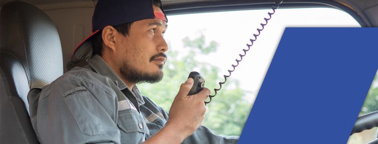 male truck driver with radio in hand wondering how long does it take to get a cdl