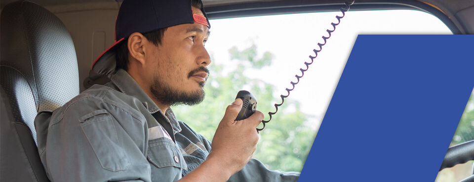 male truck driver with radio in hand wondering how long does it take to get a cdl