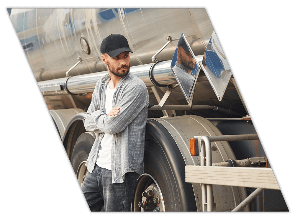 Truck driver leaning against truck during CDL contract training in Arkansas